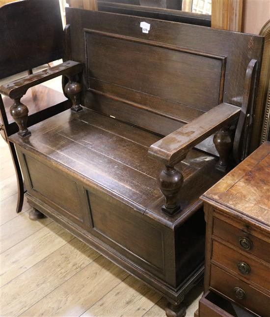 A 1930s oak monks bench, W.107cm